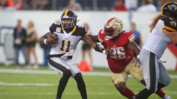 Pittsburgh Maulers Troy Williams (11) attempts to push away from Birmingham Stallions Willie Henry (96) after being trapped in the pocket during the first half of the USFL Championship game Saturday evening at Tom Benson Stadium in Canton, OH.  